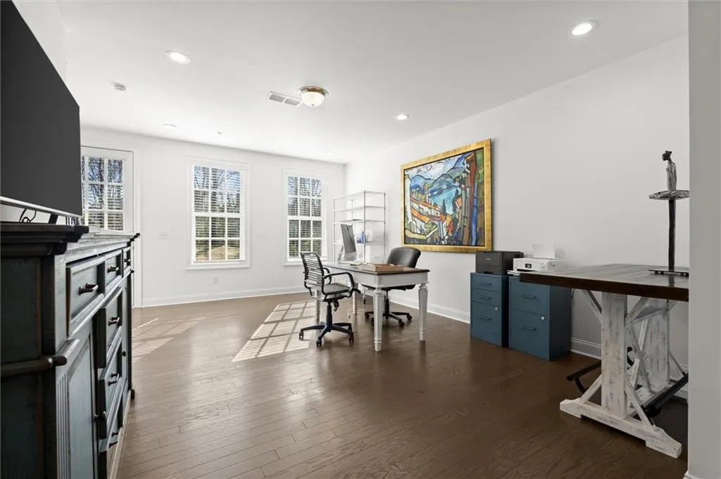 Office featuring dark wood-type flooring and recessed lighting