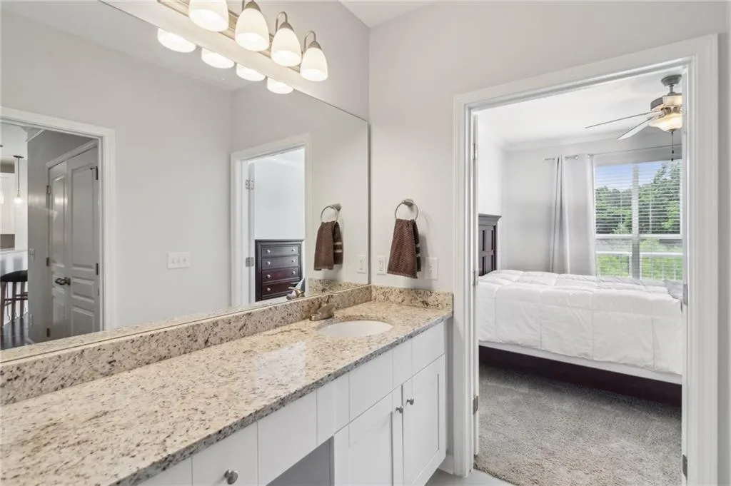 Bathroom featuring ensuite bathroom, granite countertop vanity