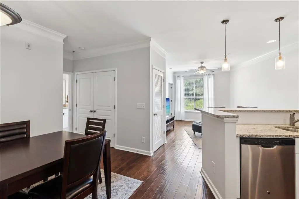 Dining area featuring dark wood finished floors, crown molding, ceiling fan, and baseboards