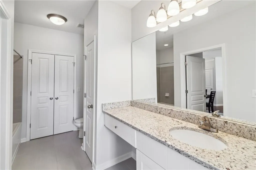 Bathroom with a closet, toilet, vanity