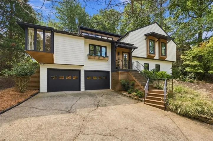 Contemporary exterior featuring white siding and black trim accents