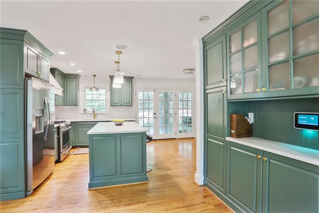Kitchen with stainless steel finishes, light countertops, and a kitchen island