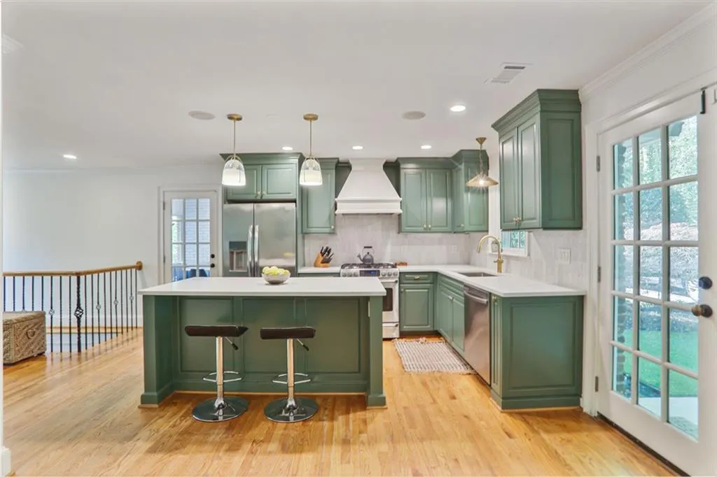 Kitchen featuring custom exhaust hood, and stainless steel appliances