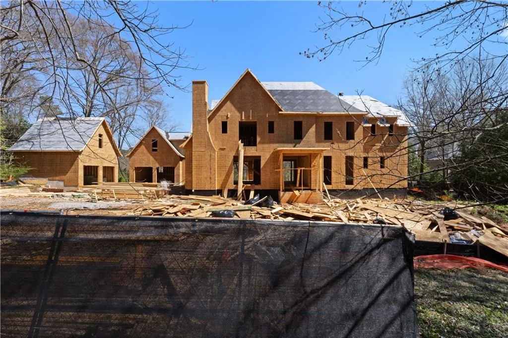 Back of property with a chimney and fence
