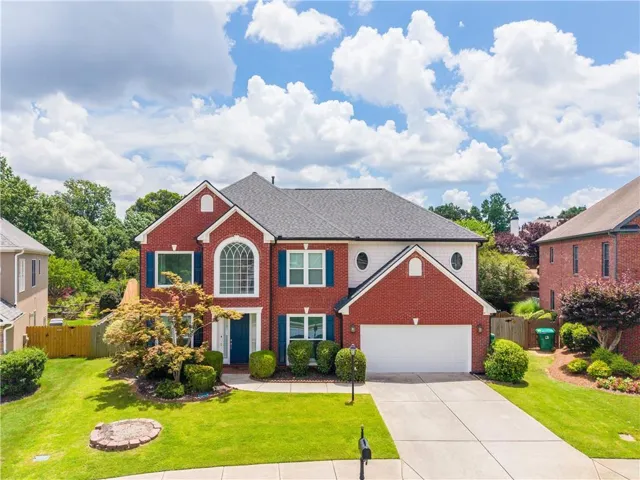Two-story brick and siding residence featuring a gabled roofline