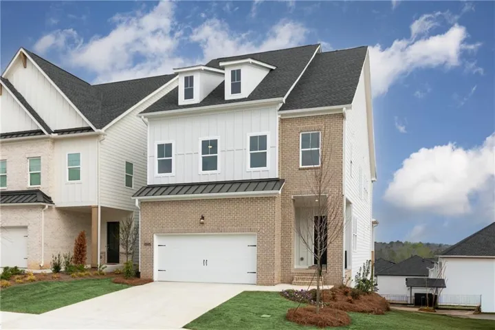 Modern exterior with light brick and white vertical siding, prominent dormer windows, attached two-car garage, and a covered entry porch