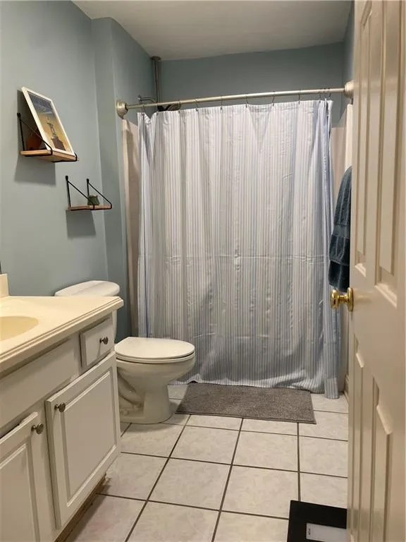 Bathroom featuring tile flooring, vanity, and toilet