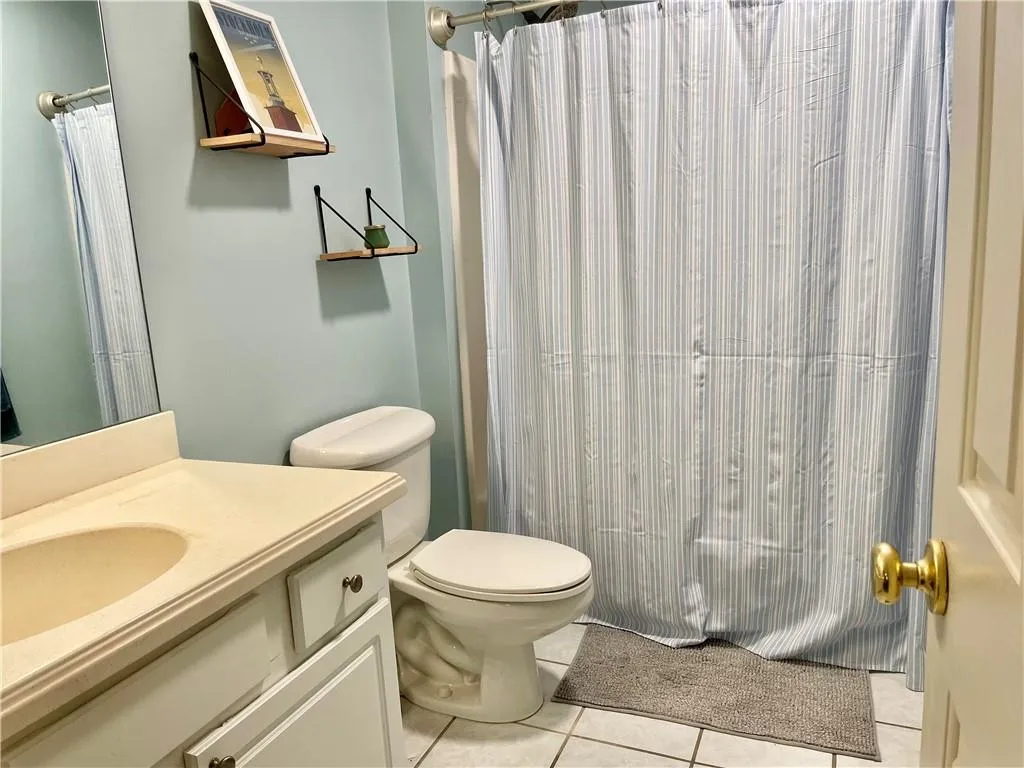 Bathroom featuring oversized vanity, tile floors, and toilet