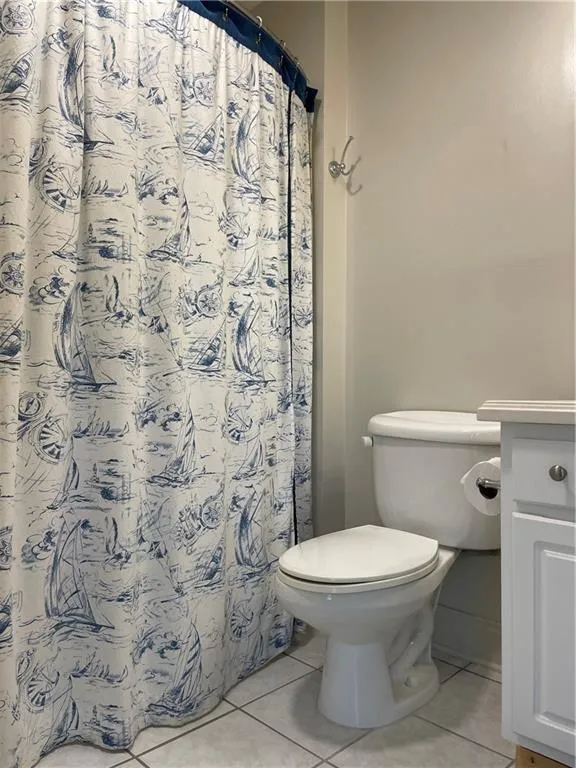 Bathroom featuring vanity, tile floors, and toilet