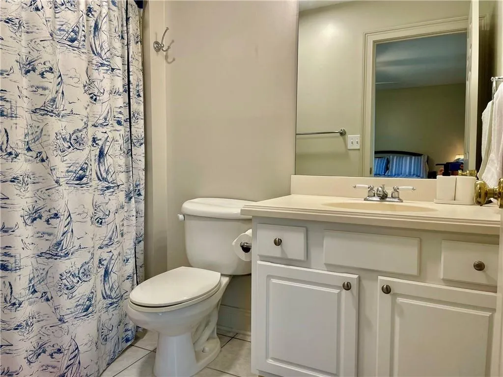 Bathroom with toilet, tile flooring, and vanity