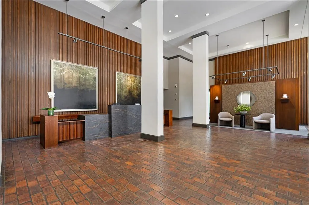 Reception area with wood walls, a tray ceiling, and recessed lighting