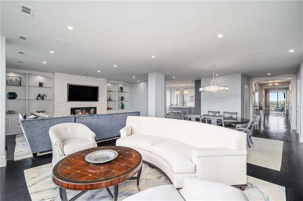 Living area with hardwood / wood-style flooring, a fireplace, recessed lighting, and built in shelves