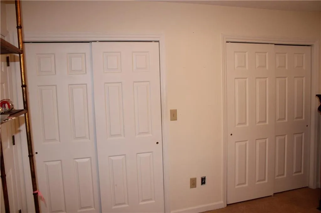 Bedroom featuring multiple closets and carpet flooring Bedroom featuring multiple closets and carpet flooring