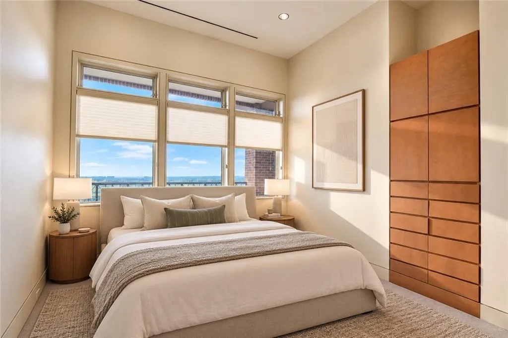 Expansive window array, recessed lighting, built-in wood-finish cabinetry with drawers, neutral wall tones, and light-colored carpeting