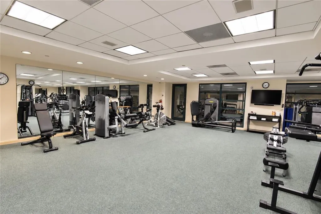 Fitness center featuring mirrored walls, recessed lighting, and various exercise equipment