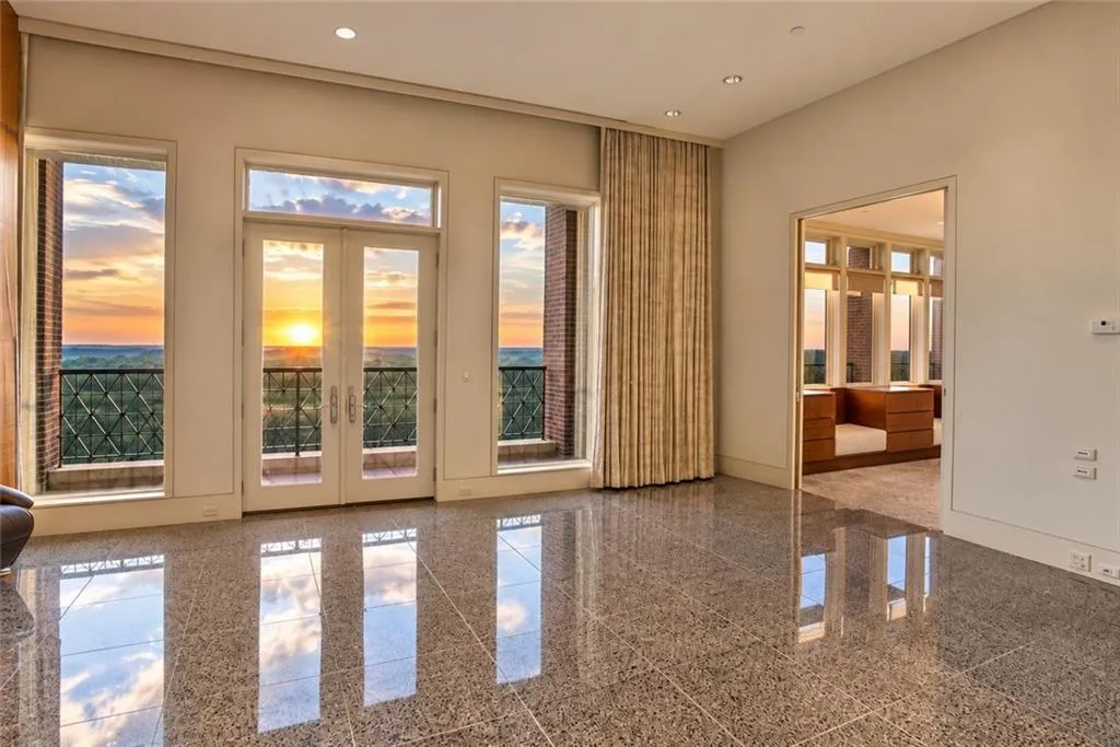 Polished terrazzo flooring, expansive windows, glass French doors, recessed lighting, and full-height drapery