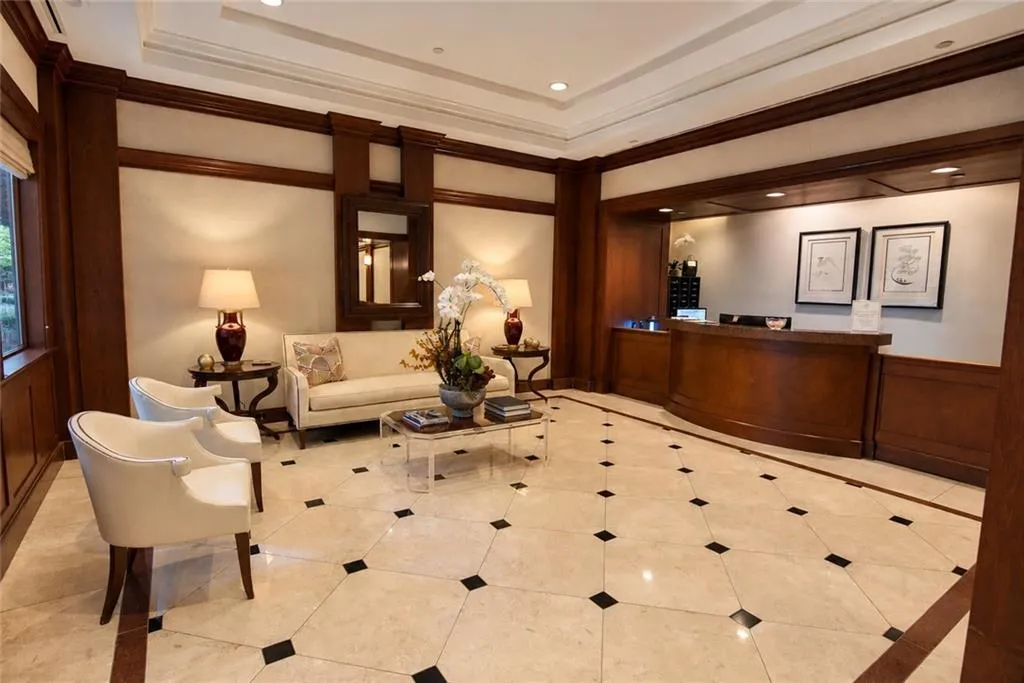 Spacious reception area featuring a wood-paneled desk, patterned tile flooring, and recessed lighting