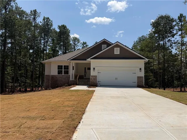 Contemporary single-story residence featuring a two-car garage, brick and siding exterior, a gabled roofline, and a concrete driveway
