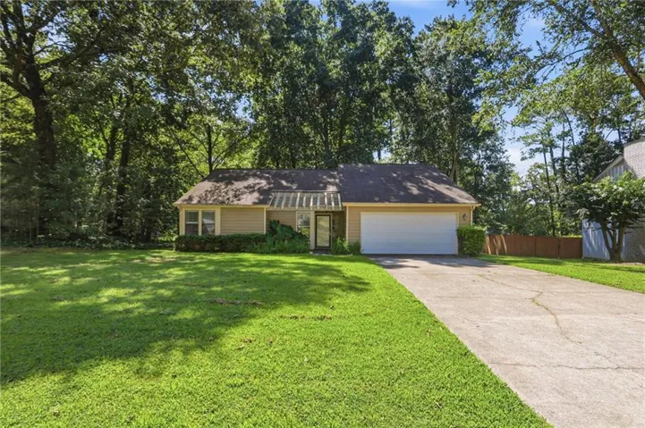Single-story residence with a two-car garage, concrete driveway, and front lawn
