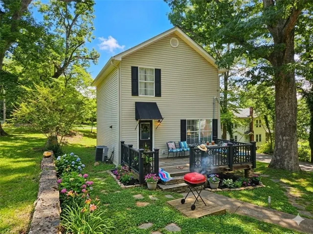 Two-story home with light-colored siding and black shutters