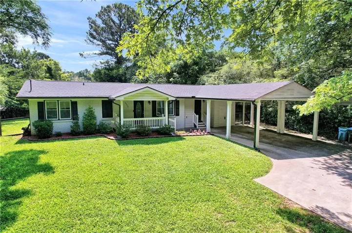 Ranch-style residence featuring a white exterior, a covered front porch with white railings, and a two-car carport