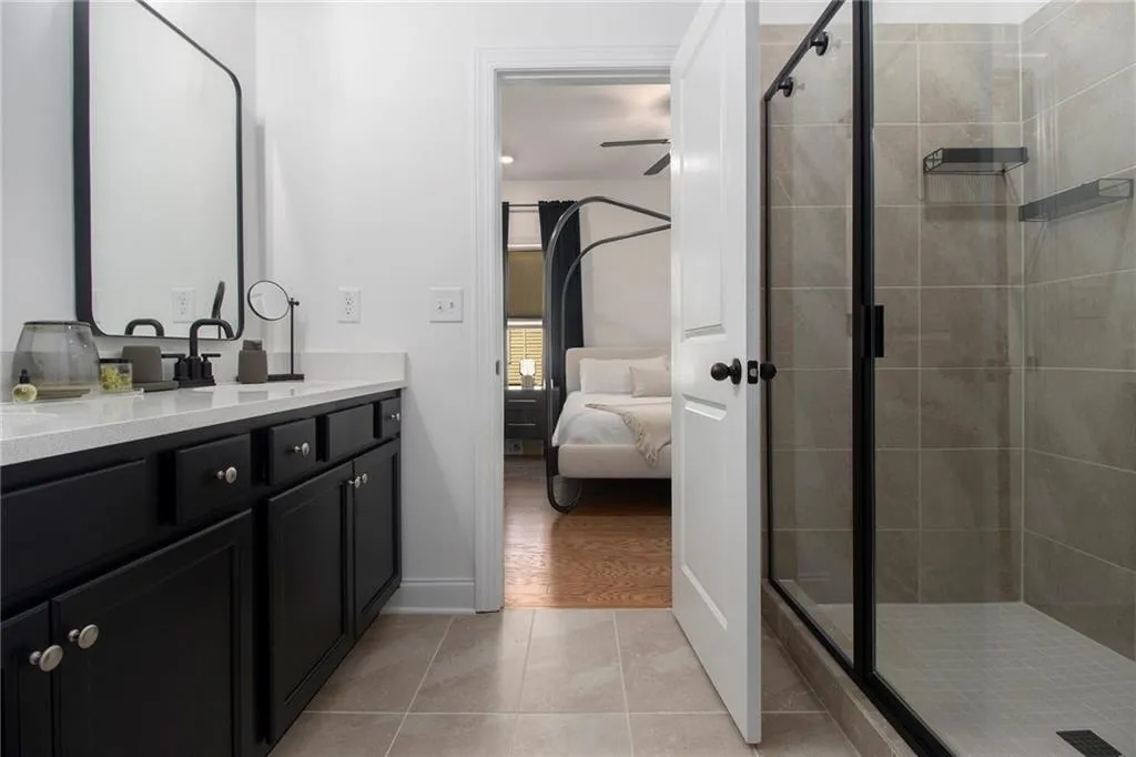 Ensuite bathroom with vanity, a shower stall, and tile patterned flooring