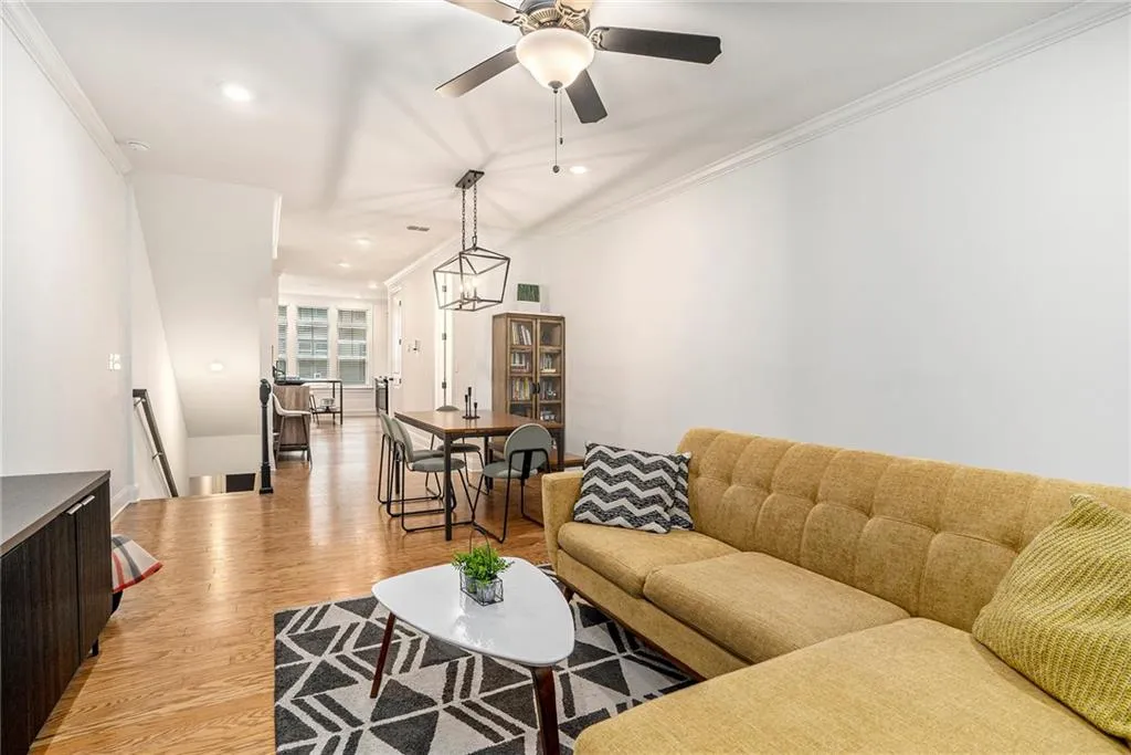 Living room with ceiling fan, light wood finished floors, ornamental molding, and recessed lighting