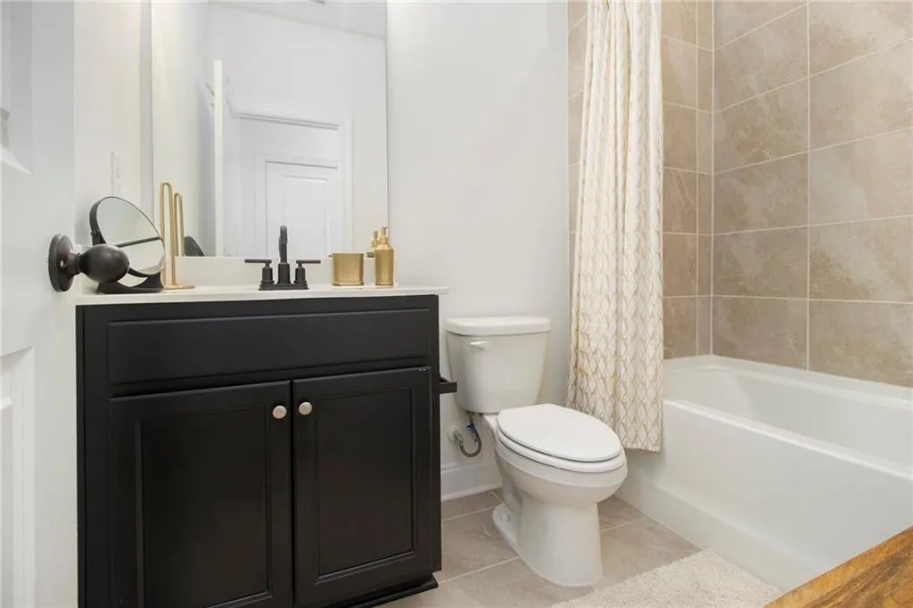Full bath with tile patterned floors, vanity, and shower / bath combination with curtain