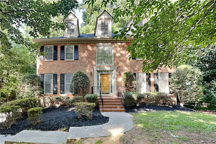 Brick exterior featuring a gabled roofline with two dormer windows