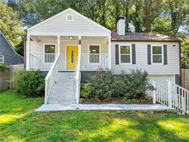 View of front of home with covered porch, a chimney, and an attached garage