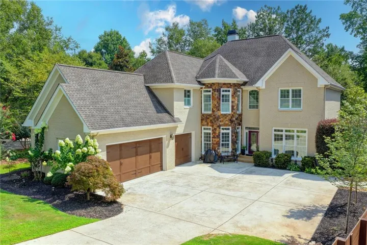 Expansive concrete driveway with a three-car garage
