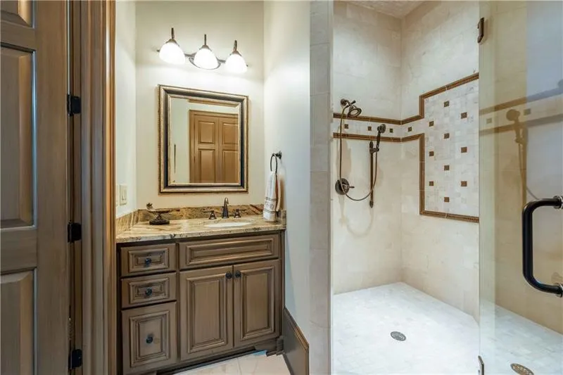 Bathroom with vanity, tiled shower, and tile floors