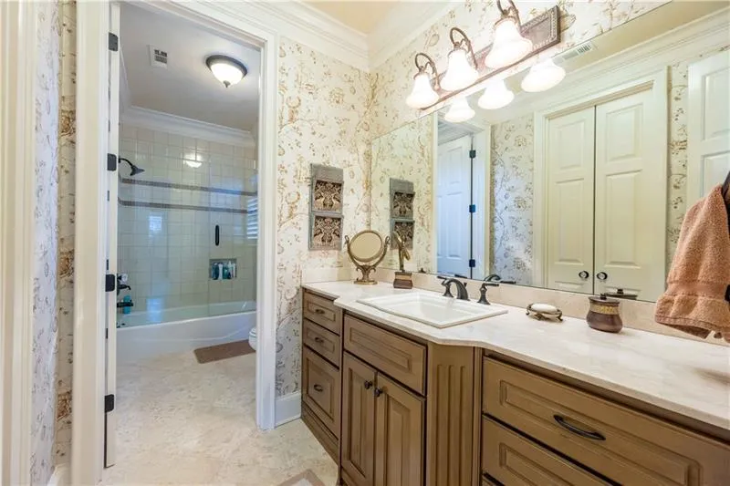 Full bathroom featuring toilet, tile flooring, vanity, tiled shower / bath, and ornamental molding