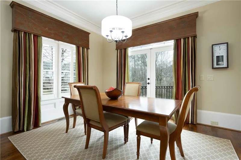Dining space featuring crown molding, a notable chandelier, hardwood / wood-style floors, and french doors