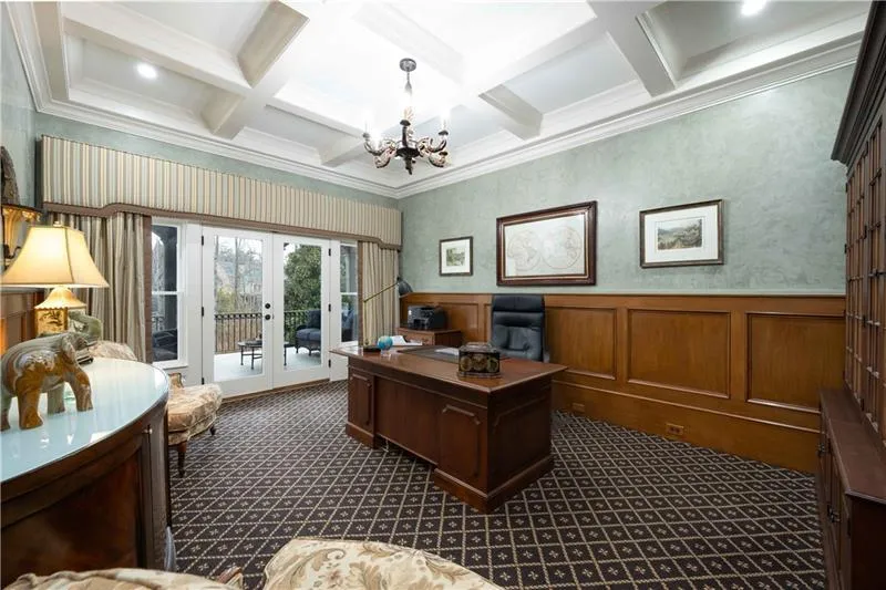 Carpeted office space with crown molding, coffered ceiling, french doors, and a notable chandelier