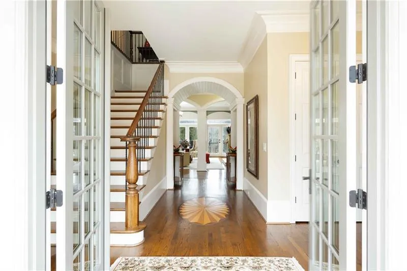 Foyer with crown molding, dark hardwood / wood-style floors, and french doors