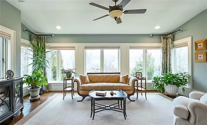 Sunroom / solarium with a wealth of natural light and ceiling fan