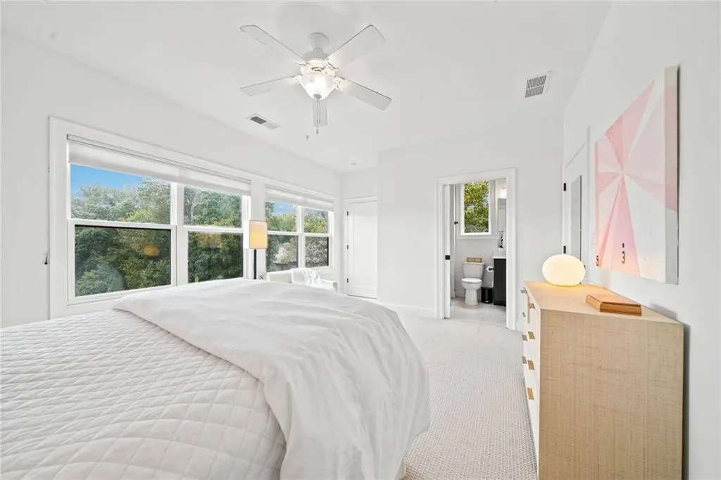 Bedroom featuring connected bathroom, ceiling fan, and light colored carpet