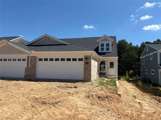 View of front of house with an attached garage, a front lawn, driveway, and brick siding