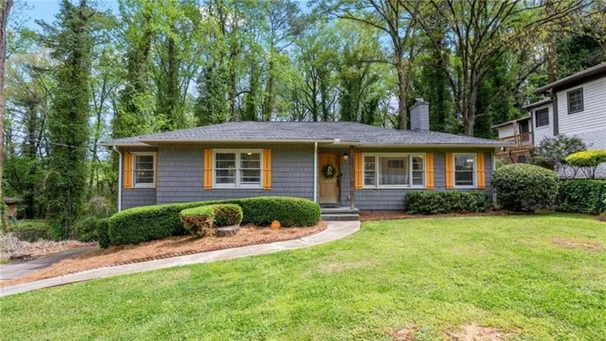 Ranch-style residence featuring grey siding, yellow window shutters, and a grey shingle roof