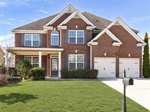Brick exterior with white trim details and a covered porch entry