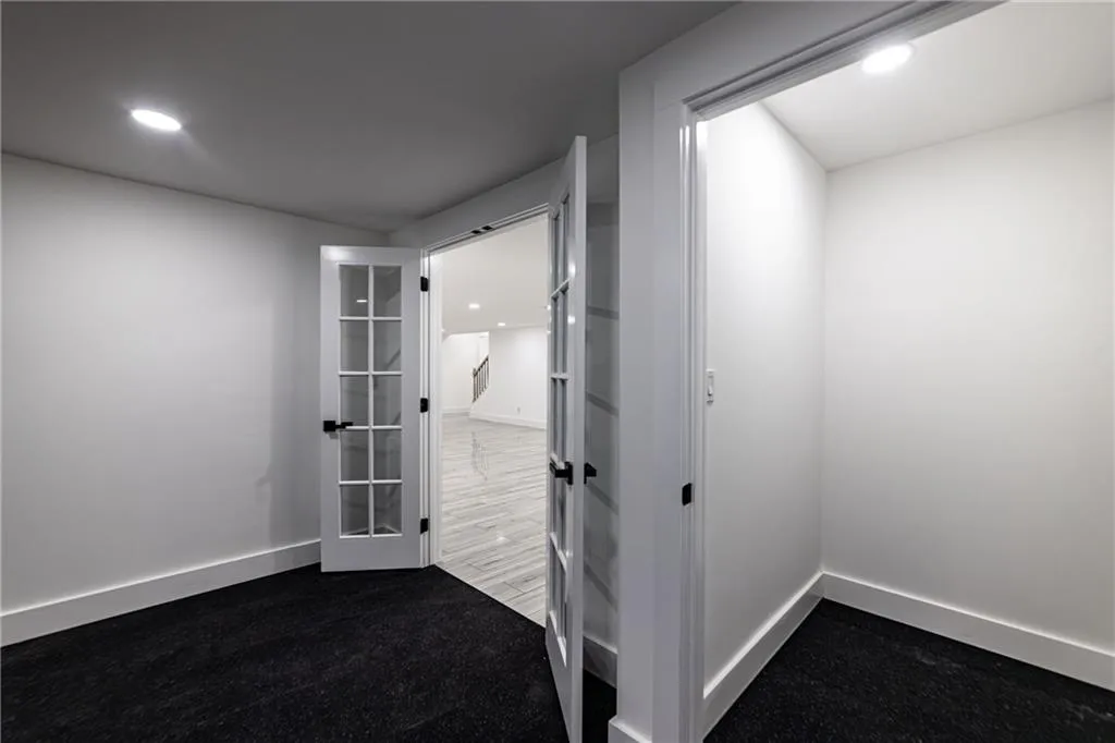 Empty room featuring recessed lighting and dark colored carpet