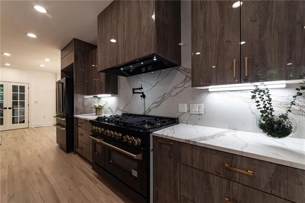 Kitchen with range with two ovens, tasteful backsplash, modern cabinets, freestanding refrigerator, and recessed lighting