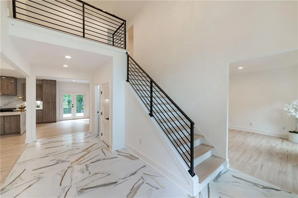 Staircase with recessed lighting, marble finish flooring, french doors, and a high ceiling