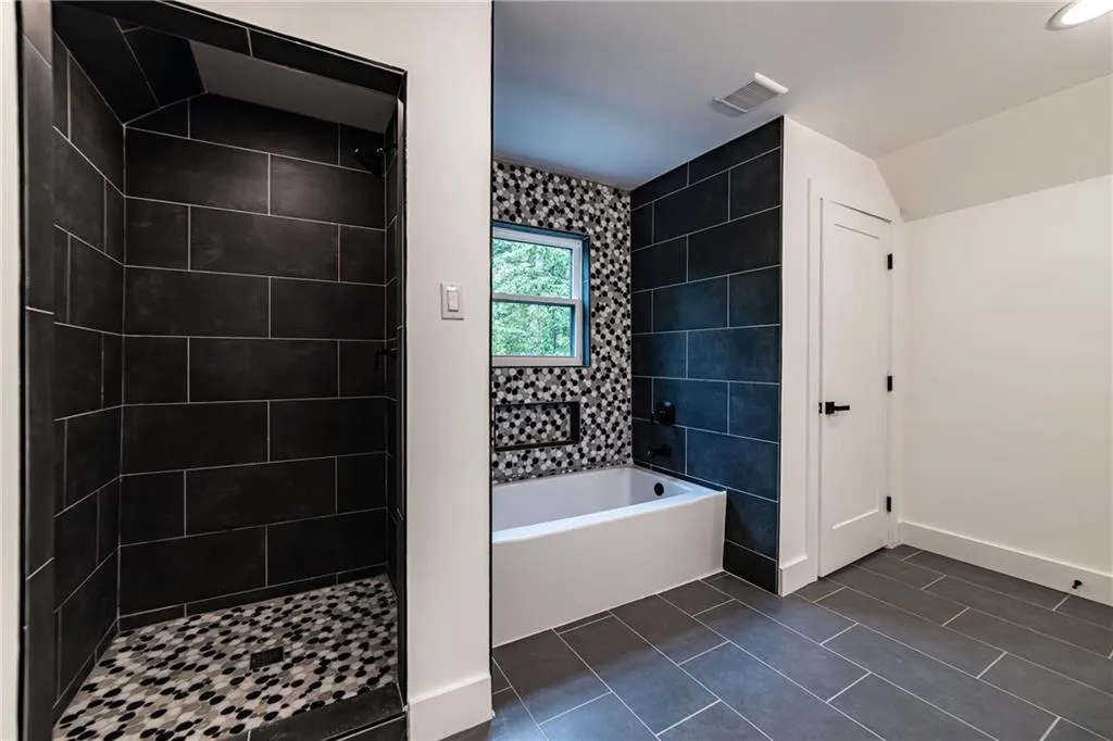 Bathroom with a garden tub, tiled shower, and tile patterned floors