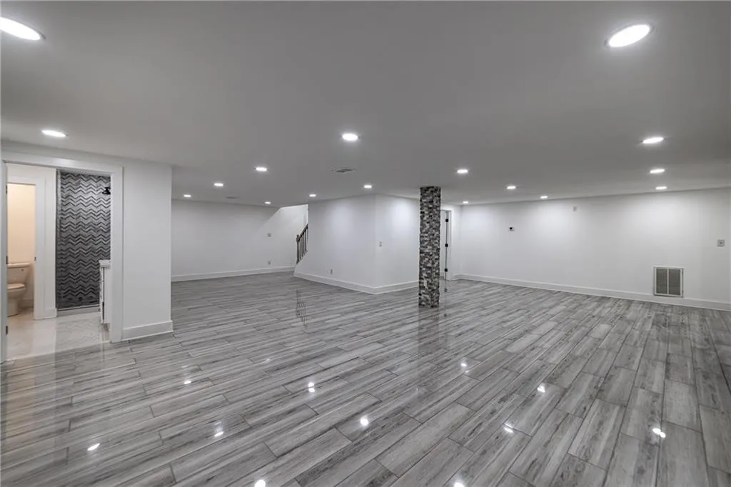 Finished basement with recessed lighting, wood finish floors, and stairway