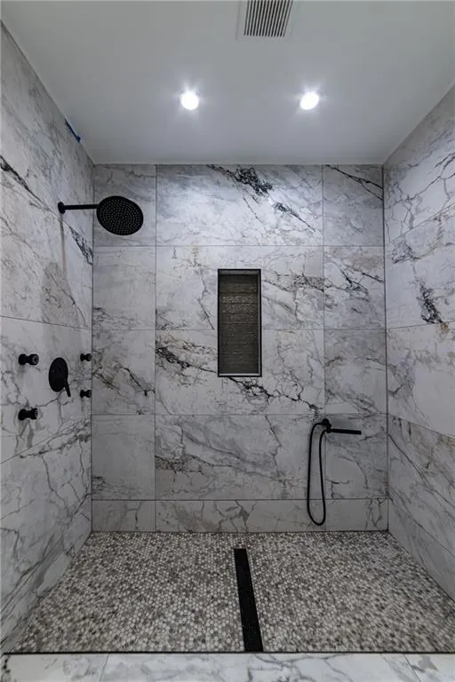 Bathroom with a tile shower and recessed lighting