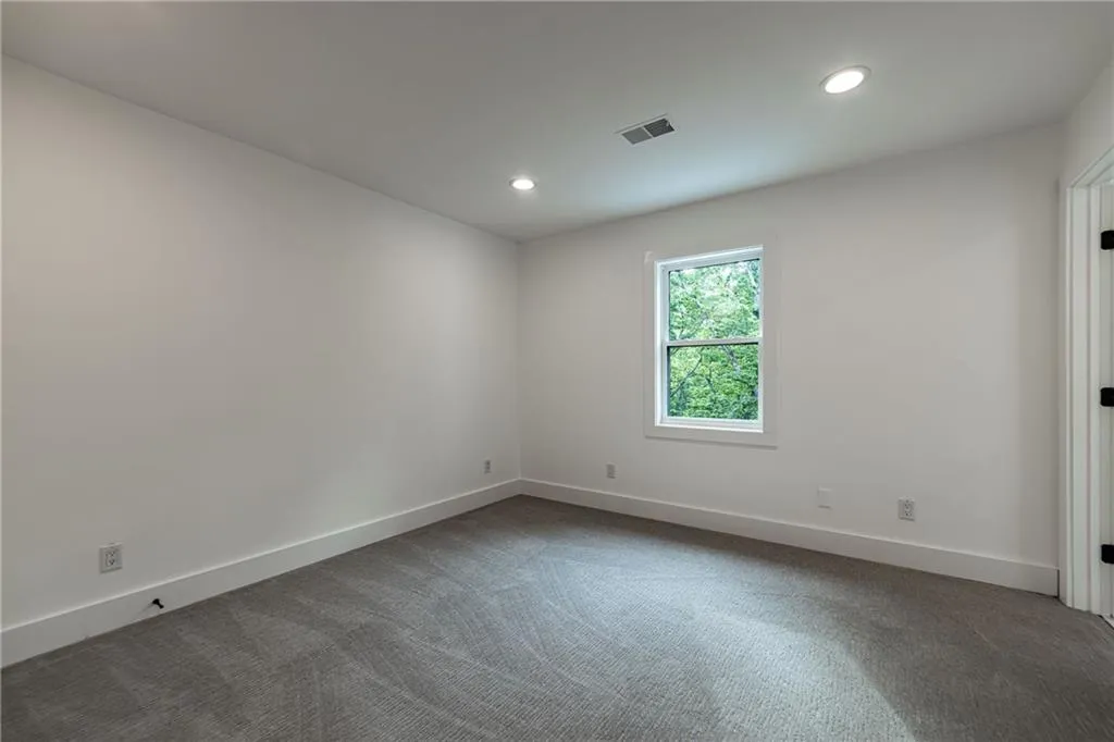 Spare room featuring dark carpet and recessed lighting