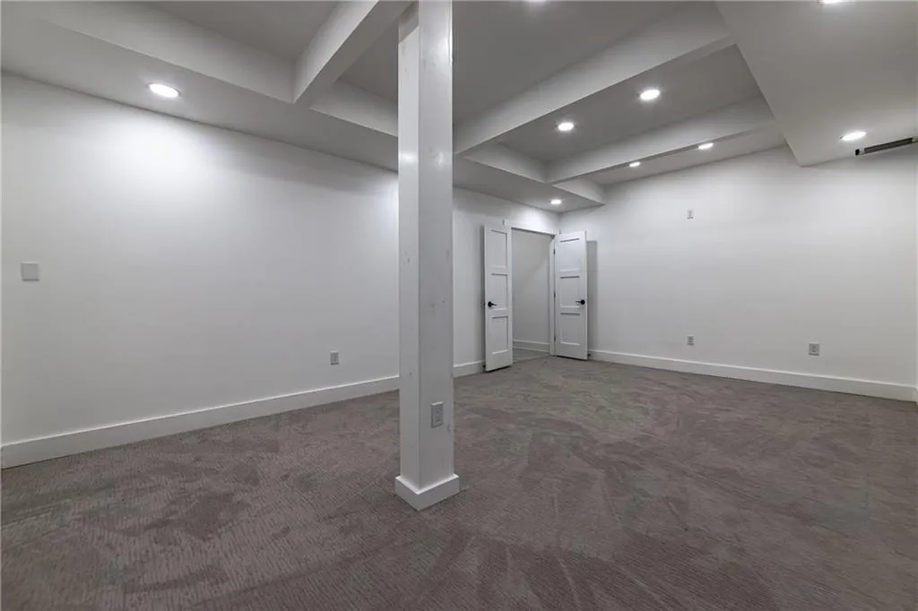 Finished basement featuring dark colored carpet and recessed lighting