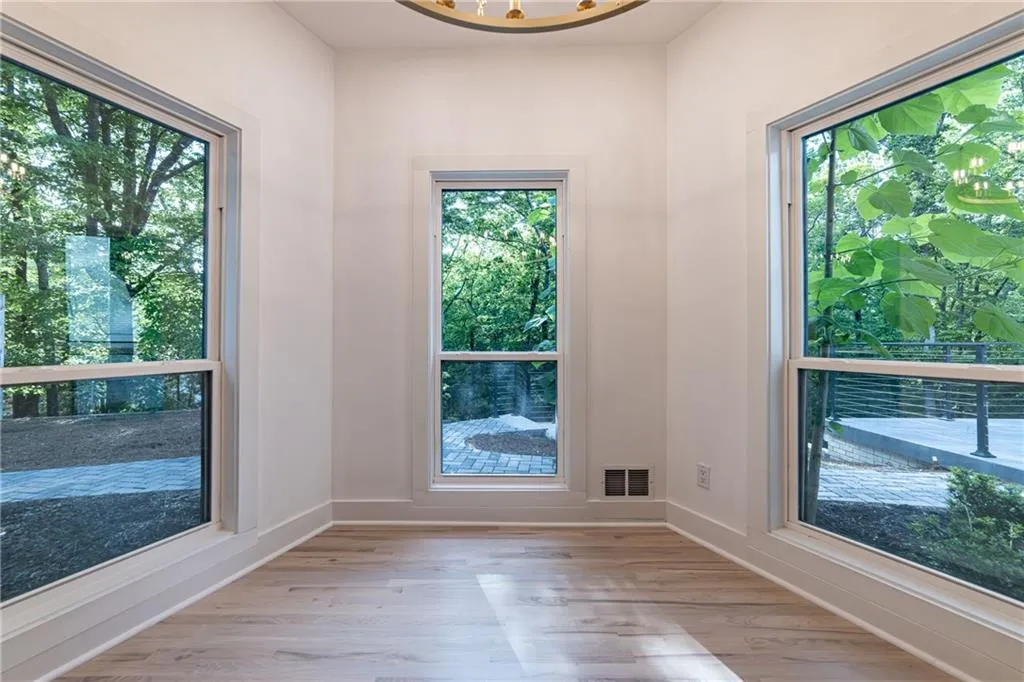 Doorway to outside featuring a chandelier and light wood-type flooring
